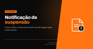Pessoa sentada à mesa lendo um documento oficial impresso ao lado de uma carteira de habilitação